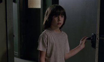 Movie still from “The Cement Garden” (1993), directed by Andrew Birkin – A young boy standing in front of a wall; Close Up shot, Low angle