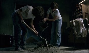 Movie still from “The Cement Garden” (1993), directed by Andrew Birkin – A couple of people digging a hole with a shovel; Wide shot, High angle