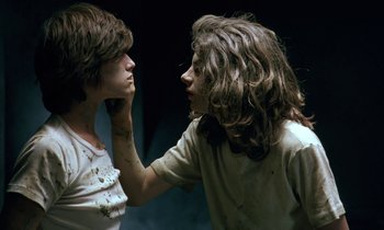 Movie still from “The Cement Garden” (1993), directed by Andrew Birkin – Two young people with long brown hair touching each other's face; Close Up shot, Over the shoulder angle
