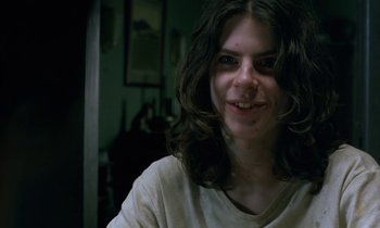 Movie still from “The Cement Garden” (1993), directed by Andrew Birkin – A woman with long dark hair smiling for the camera; Close Up shot, Low angle