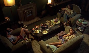 Movie still from “The Cement Garden” (1993), directed by Andrew Birkin – A group of people sitting around a living room; Wide shot, High angle