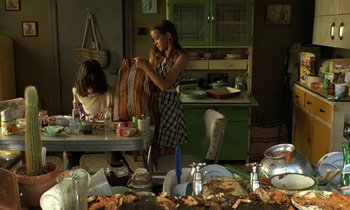 Movie still from “The Cement Garden” (1993), directed by Andrew Birkin – Two young girls are sitting at a kitchen table; Medium shot, High angle