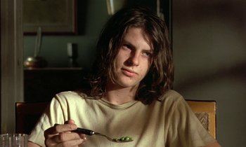 Movie still from “The Cement Garden” (1993), directed by Andrew Birkin – A person with long hair holding a spoon; Close Up shot, Low angle