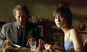 Movie still from “The Cement Garden” (1993), directed by Andrew Birkin – A man and a woman sitting at a dinner table; Close Up shot, Low angle