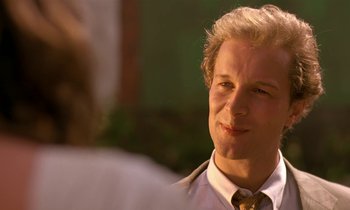 Movie still from “The Cement Garden” (1993), directed by Andrew Birkin – A man in a suit and tie is looking to his left; Close Up shot, Over the shoulder angle