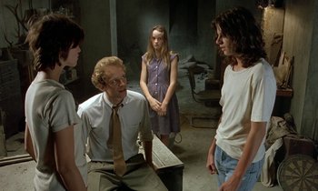 Movie still from “The Cement Garden” (1993), directed by Andrew Birkin – A group of people standing in a room; Medium shot, Over the shoulder angle