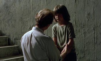 Movie still from “The Cement Garden” (1993), directed by Andrew Birkin – A man and a boy are standing next to each other; Medium shot, Over the shoulder angle
