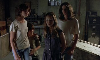 Movie still from “The Cement Garden” (1993), directed by Andrew Birkin – A group of young people standing in a room together; Medium shot, Low angle