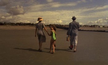 Movie still from “The Cement Garden” (1993), directed by Andrew Birkin – An older woman and a young girl walking with an older man; Wide shot, High angle