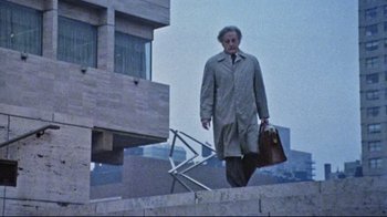 Movie still from “The Changeling” (1980), directed by Peter Medak – An older man in a trench coat carrying a briefcase; Wide shot, Low angle
