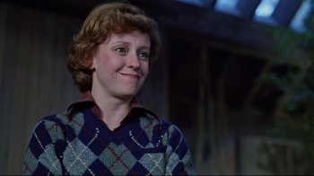 Movie still from “The Changeling” (1980), directed by Peter Medak – A woman in a blue and red sweater smiling; Close Up shot, Over the shoulder angle