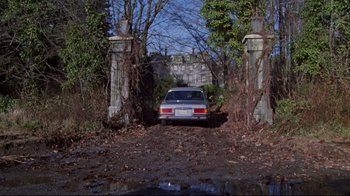 Movie still from “The Changeling” (1980), directed by Peter Medak – A car parked in the middle of a driveway; Wide shot, High angle