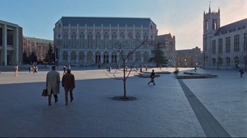 Movie still from “The Changeling” (1980), directed by Peter Medak – People are walking on a sidewalk near a building; Extreme Wide shot, High angle