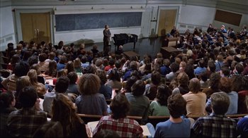 Movie still from “The Changeling” (1980), directed by Peter Medak – A large group of people sitting in front of an audience; Wide shot, High angle