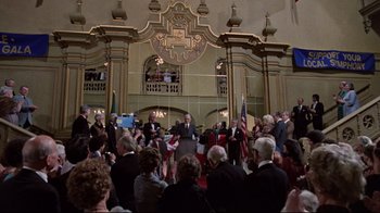 Movie still from “The Changeling” (1980), directed by Peter Medak – A crowd of people in a large room; Wide shot, High angle