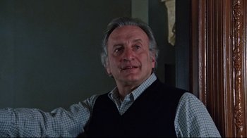 Movie still from “The Changeling” (1980), directed by Peter Medak – An older man wearing a plaid shirt and a vest; Close Up shot, Low angle