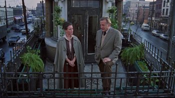 Movie still from “The Changeling” (1980), directed by Peter Medak – A man and a woman standing next to each other on a balcony; Wide shot, Low angle