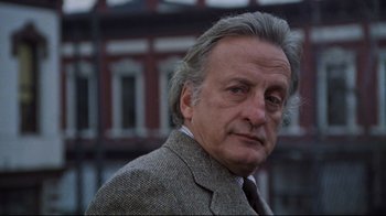 Movie still from “The Changeling” (1980), directed by Peter Medak – An older man in a jacket and tie; Close Up shot, Low angle