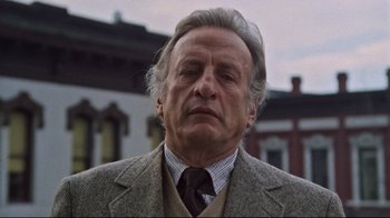 Movie still from “The Changeling” (1980), directed by Peter Medak – An older man wearing a suit and a tie; Close Up shot, Low angle