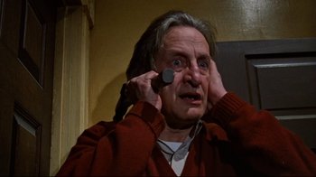 Movie still from “The Changeling” (1980), directed by Peter Medak – An older man holding a cell phone up to his ear; Close Up shot, Low angle