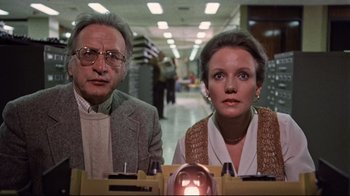 Movie still from “The Changeling” (1980), directed by Peter Medak – A man and a woman sitting at a table; Medium shot, Low angle