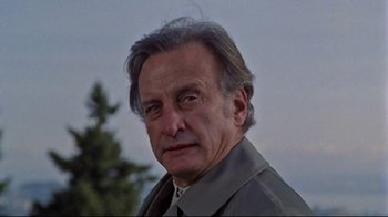 Movie still from “The Changeling” (1980), directed by Peter Medak – An older man with grey hair is looking at the camera; Close Up shot, Low angle