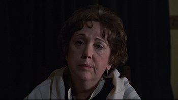 Movie still from “The Changeling” (1980), directed by Peter Medak – An older woman sitting in front of a curtain; Close Up shot, High angle