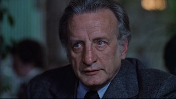 Movie still from “The Changeling” (1980), directed by Peter Medak – An older man wearing a suit and tie; Close Up shot, High angle