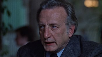 Movie still from “The Changeling” (1980), directed by Peter Medak – An older man in a suit and tie looking to his left; Close Up shot, Low angle