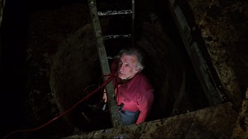 Movie still from “The Changeling” (1980), directed by Peter Medak – An older man in a red shirt is climbing up a ladder; Wide shot, Overhead angle