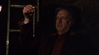 Movie still from “The Changeling” (1980), directed by Peter Medak – A man in a brown jacket holding a gold chain; Close Up shot, Low angle