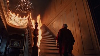 Movie still from “The Changeling” (1980), directed by Peter Medak – A man walking down a staircase with fire coming out of it; Wide shot, Low angle