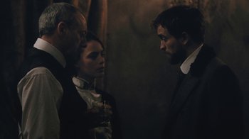 Movie still from “The Childhood of a Leader” (2015), directed by Brady Corbet – A group of people standing next to each other in a room; Medium shot, Over the shoulder angle