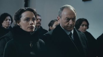 Movie still from “The Childhood of a Leader” (2015), directed by Brady Corbet – A man and a woman standing next to each other; Close Up shot, Over the shoulder angle