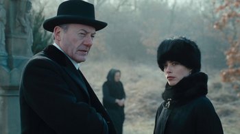 Movie still from “The Childhood of a Leader” (2015), directed by Brady Corbet – A man and a woman standing next to each other in a field; Close Up shot, Over the shoulder angle