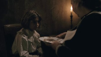 Movie still from “The Childhood of a Leader” (2015), directed by Brady Corbet – A man is serving food to a young girl; Medium shot, Over the shoulder angle
