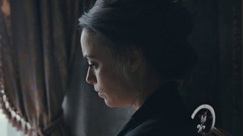 Movie still from “The Childhood of a Leader” (2015), directed by Brady Corbet – A young woman with dark hair is looking down; Close Up shot, Over the shoulder angle