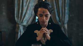 Movie still from “The Childhood of a Leader” (2015), directed by Brady Corbet – A woman with a cross on her forehead is praying; Close Up shot, Low angle
