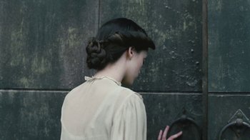 Movie still from “The Childhood of a Leader” (2015), directed by Brady Corbet – A woman with a bun and a braid in her hair; Close Up shot, Overhead angle