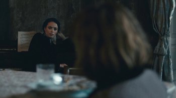 Movie still from “The Childhood of a Leader” (2015), directed by Brady Corbet – A woman sitting in front of a table with food; Medium shot, Over the shoulder angle