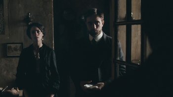 Movie still from “The Childhood of a Leader” (2015), directed by Brady Corbet – A man in a suit and tie standing next to another man; Medium shot, Over the shoulder angle