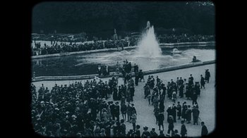 Movie still from “The Childhood of a Leader” (2015), directed by Brady Corbet – A crowd of people standing in front of a fountain; Extreme Wide shot, High angle