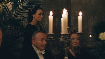 Movie still from “The Childhood of a Leader” (2015), directed by Brady Corbet – A group of people sitting in front of lit candles; Medium shot, Over the shoulder angle