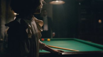 Movie still from “The Childhood of a Leader” (2015), directed by Brady Corbet – A person playing a game of billiards in a dark room; Extreme Close Up shot, Over the shoulder angle