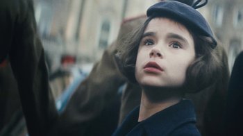 Movie still from “The Childhood of a Leader” (2015), directed by Brady Corbet – A young girl wearing a hat looking to her left; Close Up shot, Low angle