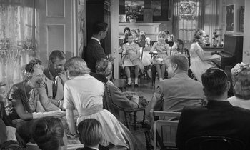 Movie still from “The Children's Hour” (1961), directed by William Wyler – A black and white photo of people sitting in chairs; Wide shot, High angle