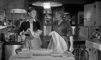 Movie still from “The Children's Hour” (1961), directed by William Wyler – Two women standing in front of a cake on a table; Medium shot, Low angle