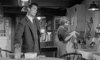 Movie still from “The Children's Hour” (1961), directed by William Wyler – A man and a woman standing in front of a table; Medium shot, Low angle