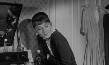 Movie still from “The Children's Hour” (1961), directed by William Wyler – A young woman leaning on a table in front of a mirror; Medium shot, Over the shoulder angle