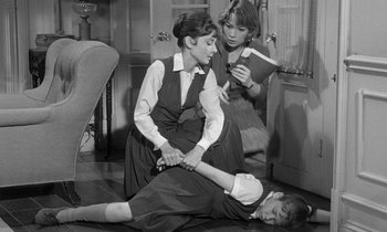 Movie still from “The Children's Hour” (1961), directed by William Wyler – Two women and a boy are playing a game; Medium shot, High angle
